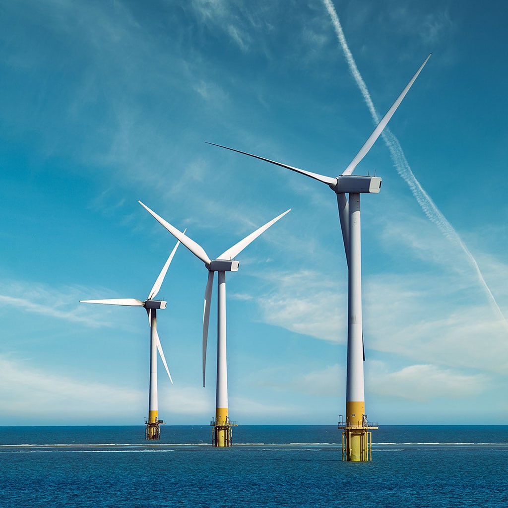 Three offshore wind turbines standing in the sea